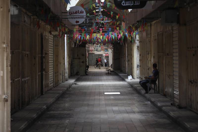 Palestinians walk in an empty street, in the West Bank city of Nablus. EPA