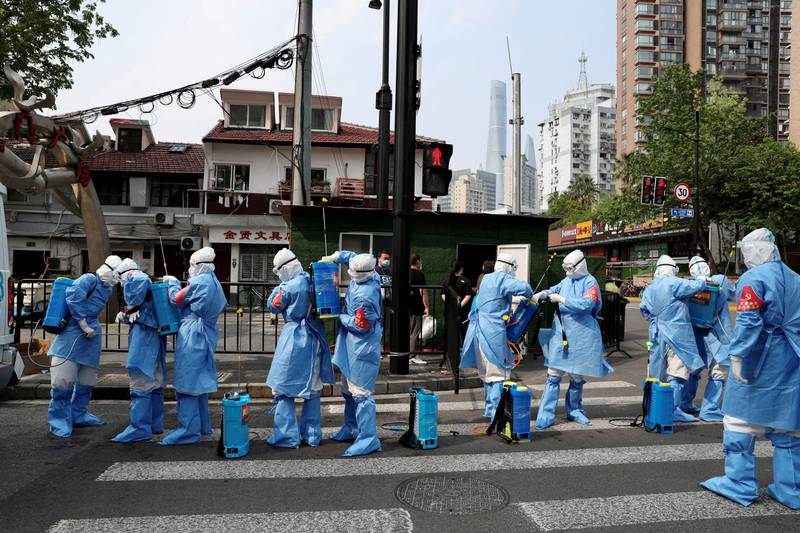 Workers in protective suits prepare to disinfect a residential compound in the Huangpu district of Shanghai, following a coronavirus outbreak. Reuters