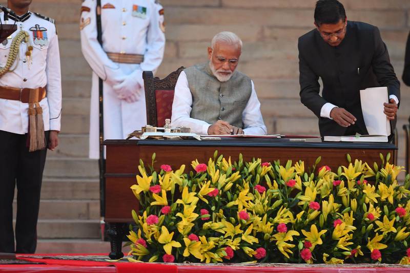 Narendra Modi signs documents after taking the oath of office as India's Prime Minister at the President house in New Delhi on May 30, 2019. AFP Photo