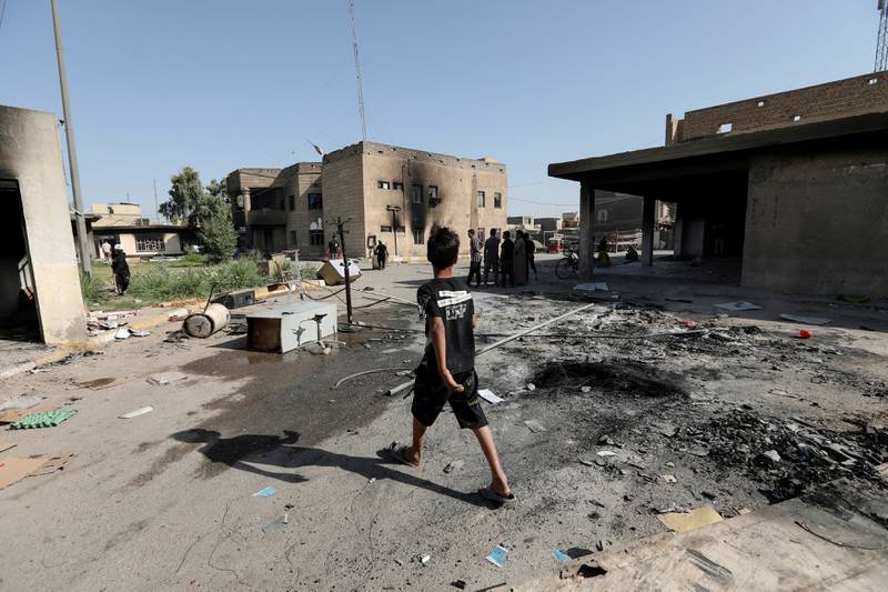 A boy walks near the office of Badr Organisation, which was burnt by supporters of Mr Al Sadr in Baghdad. Reuters