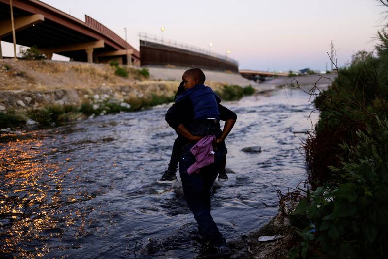 Asylum-seeking migrants cross the Rio Bravo river to turn themselves in to US Border Patrol agents to request asylum in El Paso, Texas. Reuters