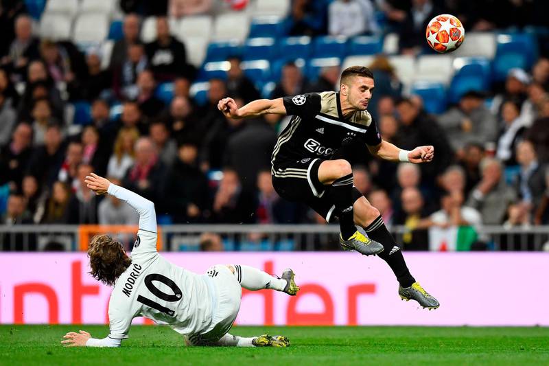 Ajax's Serbian forward Dusan Tadic challenges Real Madrid's Croatian midfielder Luka Modric. AFP