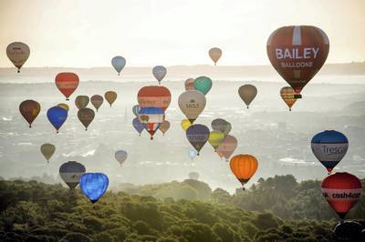Hot air balloons hover over Long Ashton, Bristol, during the mass ascent, where balloons from all over the world gather at Ashton Court, Bristol, to take part in the Bristol International Balloon Fiesta. (Photo by Ben Birchall/PA Images via Getty Images)
