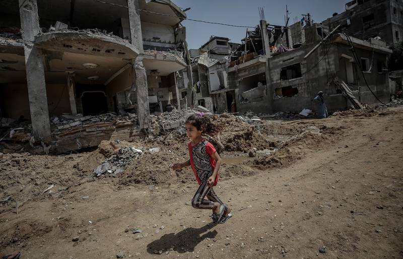A Palestinian girl runs next to her family's destroyed house after a ceasefire between Israel and Gaza fighters, in Beit Hanoun, the northern Gaza Strip. EPA