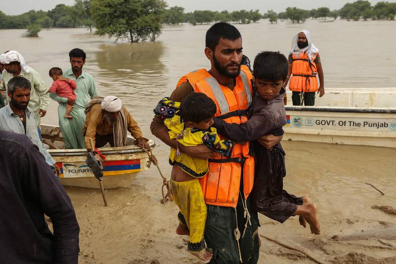 Rescue workers evacuate people from flood-hit homes in the district. AFP