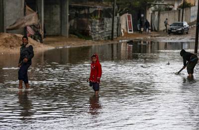 Children stand in flooded street on a rainy day in al-Amal (hope in Arabic) neighbourhood of Beit Lahia in the northern Gaza Strip.  AFP