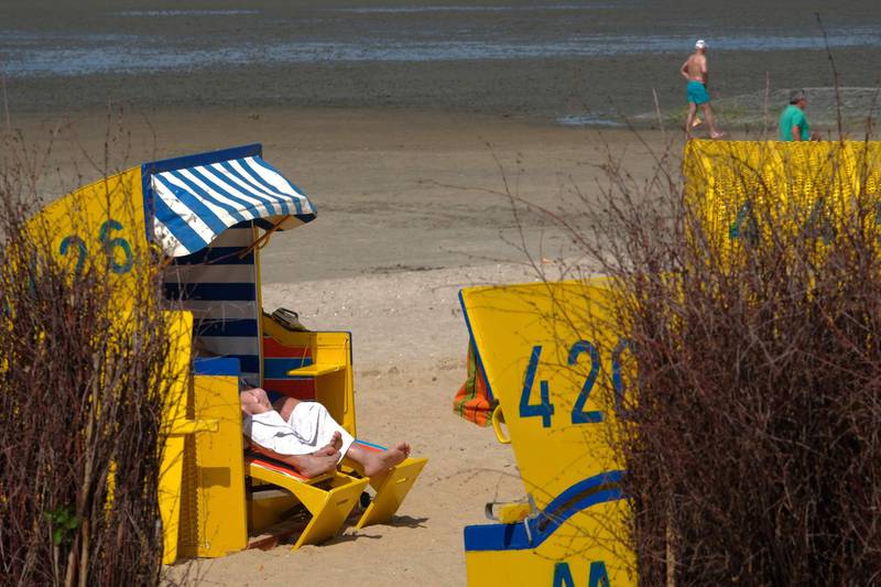 A man sits in a roofed wicker beach chair on the beach in Cuxhaven, northern Germany.  AFP
