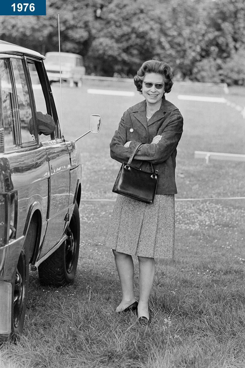 1976: The queen looking relaxed standing next to her car.