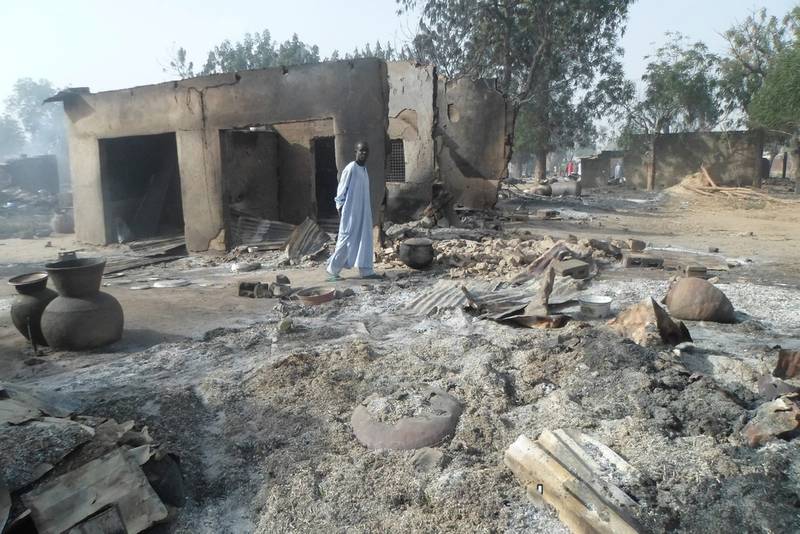 A man walks past burnt-out houses following an attack by Boko Haram extremists near Maiduguri, north-east Nigeria in 2016. AP
