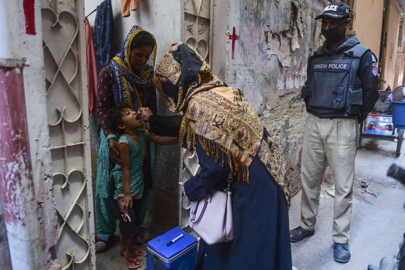 A health worker administers polio vaccine drops to a child during a door-to-door campaign in Karachi, Pakistan. AFP
