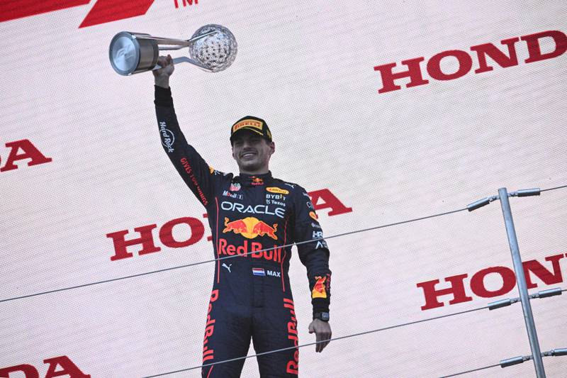 Max Verstappen poses with the trophy on the podium following his victory at the Japanese Grand Prix. AFP