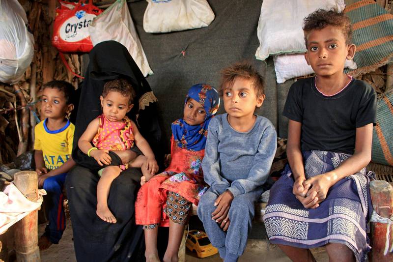 Malnourished boy Hassan Merzam Muhammad sits with his mother and brothers and sisters inside their hut in Abs district of Hajjah province, Yemen. REUTERS