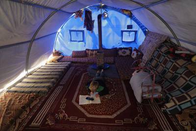 Internally displaced boy, Mahmoud Abdel Hadi, 8, does his homework received on mobile, inside his tent after his tented school was shut due to the threat of coronavirus disease in Atmeh camp, near the Turkish border, Syria. Reuters