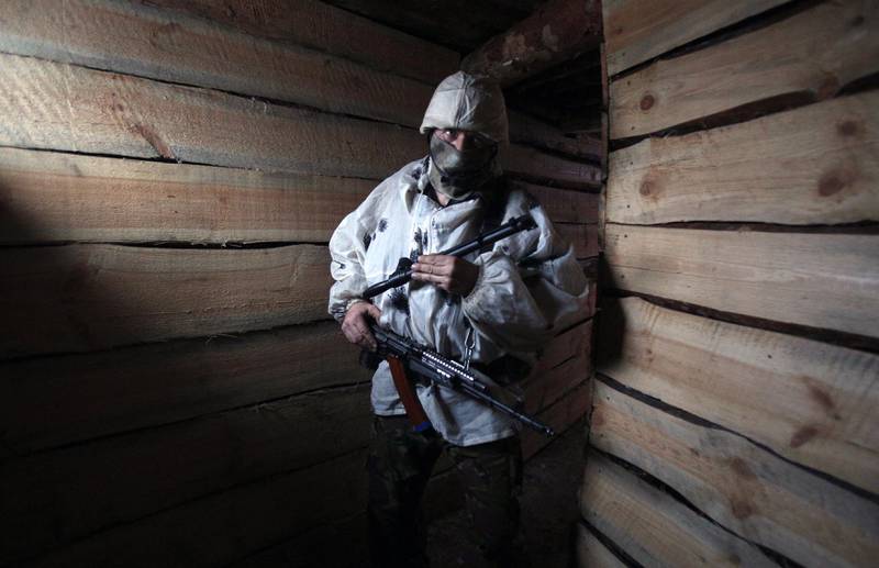 A Ukrainian serviceman stands guard in a dugout on the frontline with the Russia-backed separatists near Avdiivka. AFP