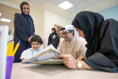 Sheikh Mansour interacts with a child as Ms Musallam, Minister of State for Early Education, looks on