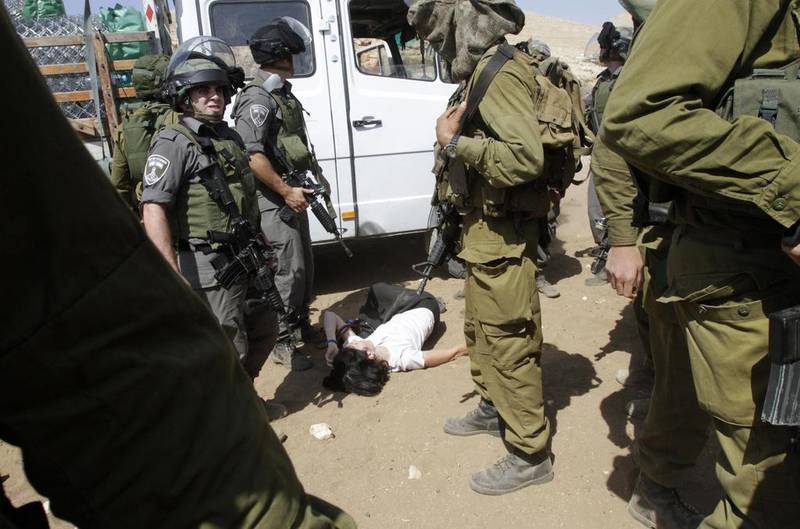 French diplomat Marion Castaing lays on the ground after Israeli soldiers carried her out of her truck containing emergency aid on Friday. Abed Omar Qusini / Reuters