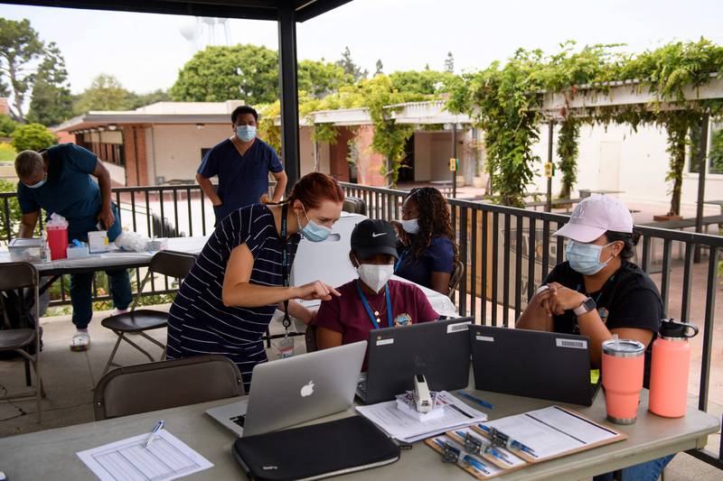 City of Long Beach Public Health employees enter vaccine record information during a Covid-19 mobile vaccination clinic at the California State University Long Beach campus. AFP
