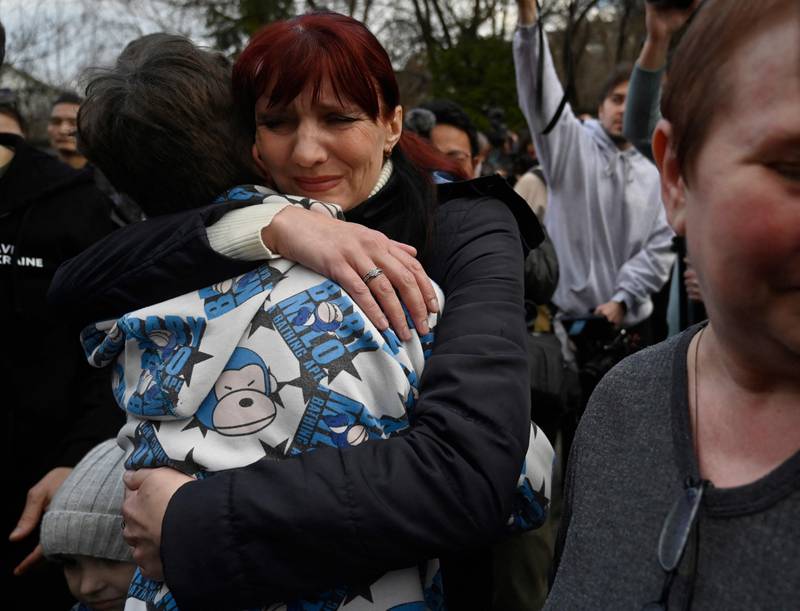 Inessa hugs her son Vitaly after the bus taking him and more than a dozen other children back from Russian-held territory arrived in Kyiv on March 22. AFP