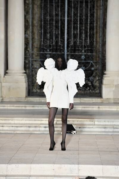 The opening look consisted of a short white dress with oversized sleeves shaped like cherubic statues.