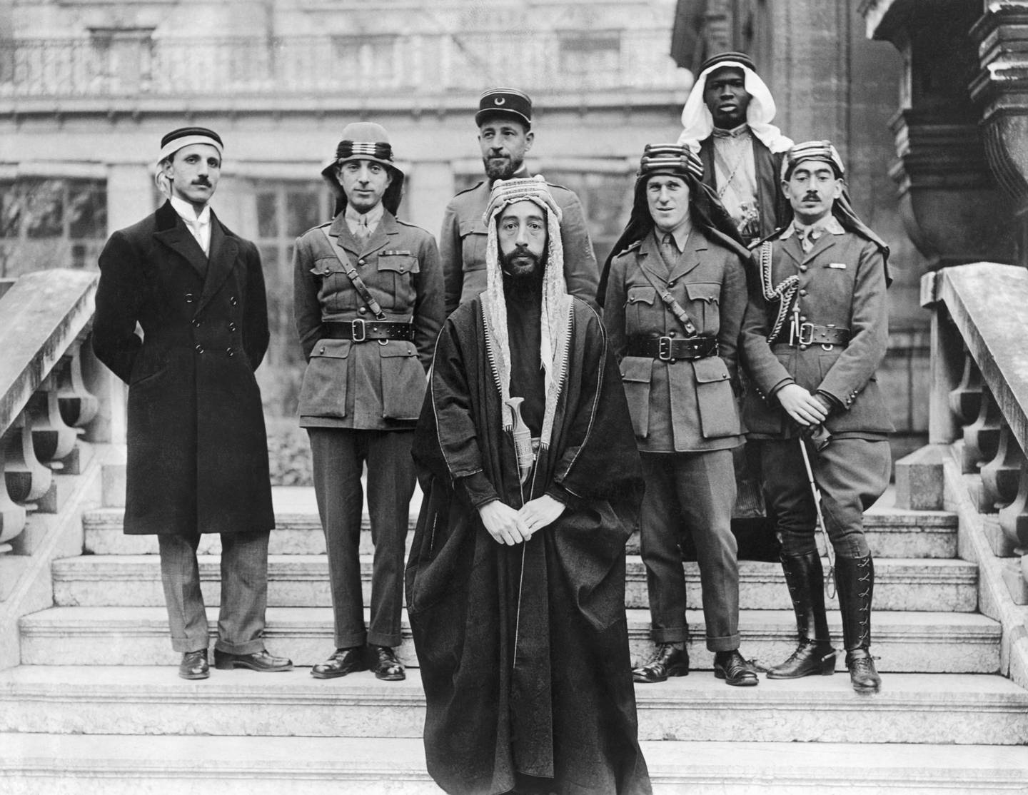 Faisal, son of Hussain of Makkah, with his delegates and advisors at the Versailles peace conference on January 22, 1919. Faisal was briefly king of Syria, and later Iraq. Behind him are (left to right) his private secretary and fellow delegate Rustem Haidar; Brig Gen Nuri Said of Baghdad; Capt Pisani of France; Col T. E. Lawrence 'of Arabia'; unidentified man; and Hassan Kadri.