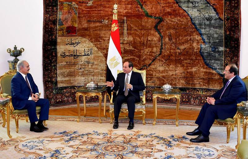 This handout picture released by the Egyptian Presidency on April 14, 2019, shows Egyptian president Abdel Fattah al-Sisi (C) and intelligence chief Abbas Kamel (R) meeting Libyan strongman Khalifa Haftar (L) at the Ittihadia presidential Palace in the capital Cairo.  Egyptian President Abdel Fattah al-Sisi met Sunday with Libyan commander Khalifa Haftar whose forces are fighting for control of the capital Tripoli, state media reported. Sisi has been an ardent supporter of Haftar's forces, which control swathes of eastern Libya and launched an offensive on April 4 to take the capital. / AFP / Egyptian Presidency / -
