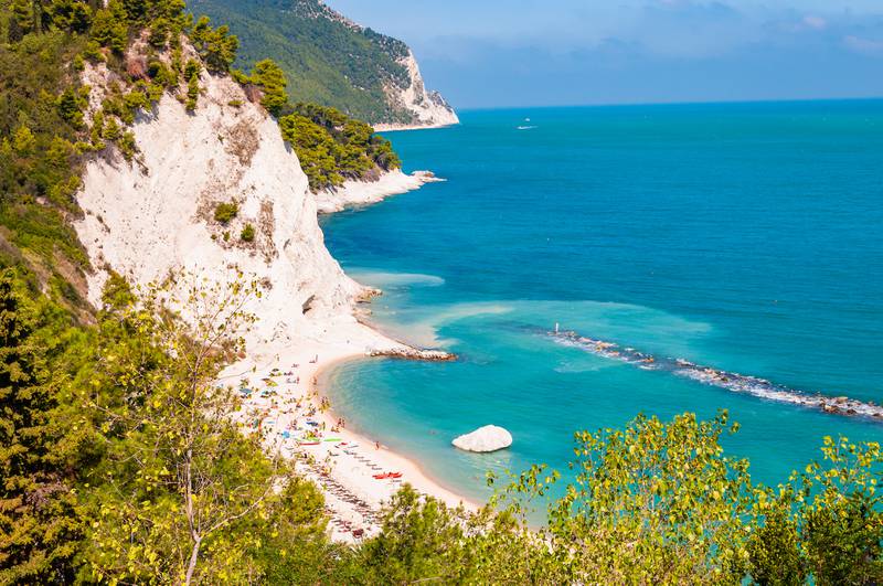 7. Beautiful coastline of Numana, Province of Ancona, Italy, surrounded by high massive white limestone rocky cliffs eroded by Adriatic sea waves and wind.