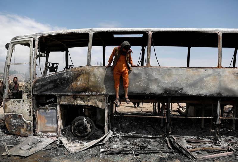 A man jumps out of a burnt bus after an overnight fire. Reuters