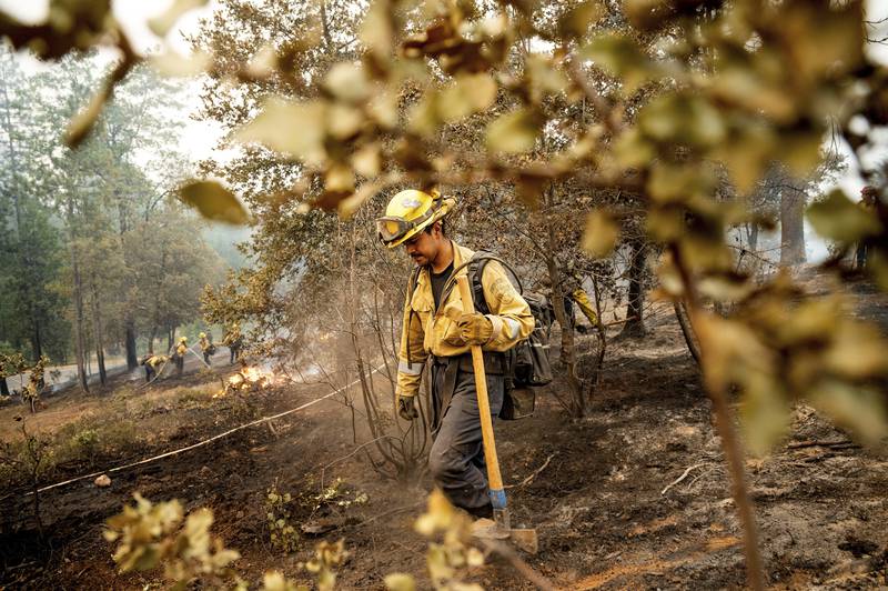 A firefighter battles the Oak Fire in the Jerseydale community of Mariposa County, California. AP