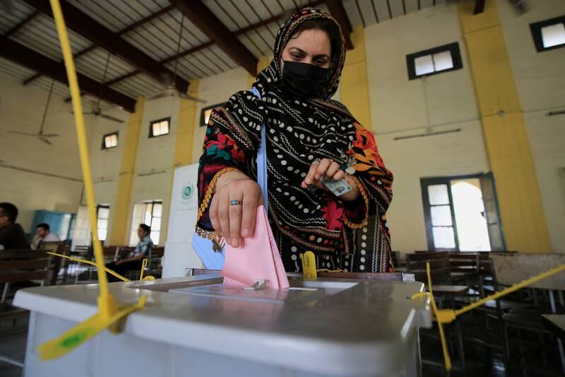 A Kashmiri woman living in Peshawar casts her vote for members of the legislative assembly of Pakistani-administered Kashmir, at a polling station in Peshawar, Pakistan, on July 25, 2021.  EPA