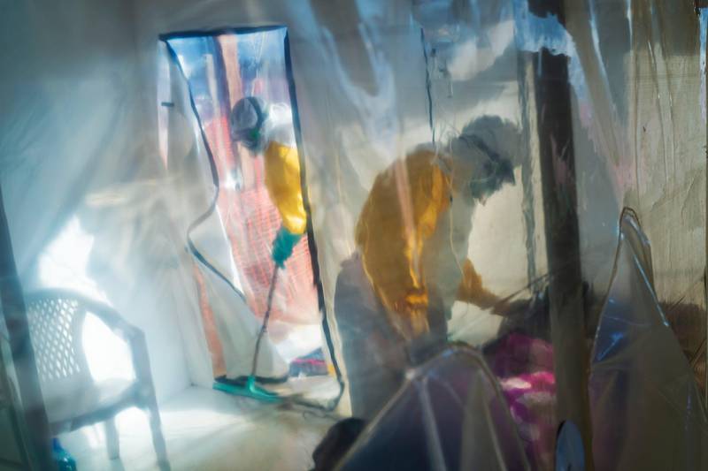 Health workers wearing protective suits tend to an Ebola victim kept in an isolation cube in Beni, Congo, on July 13, 2019. (AP Photo/Jerome Delay)