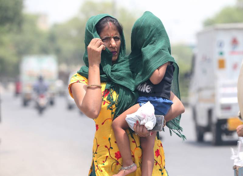 A woman and child try to beat the heatwave in New Delhi on May 9.  EPA