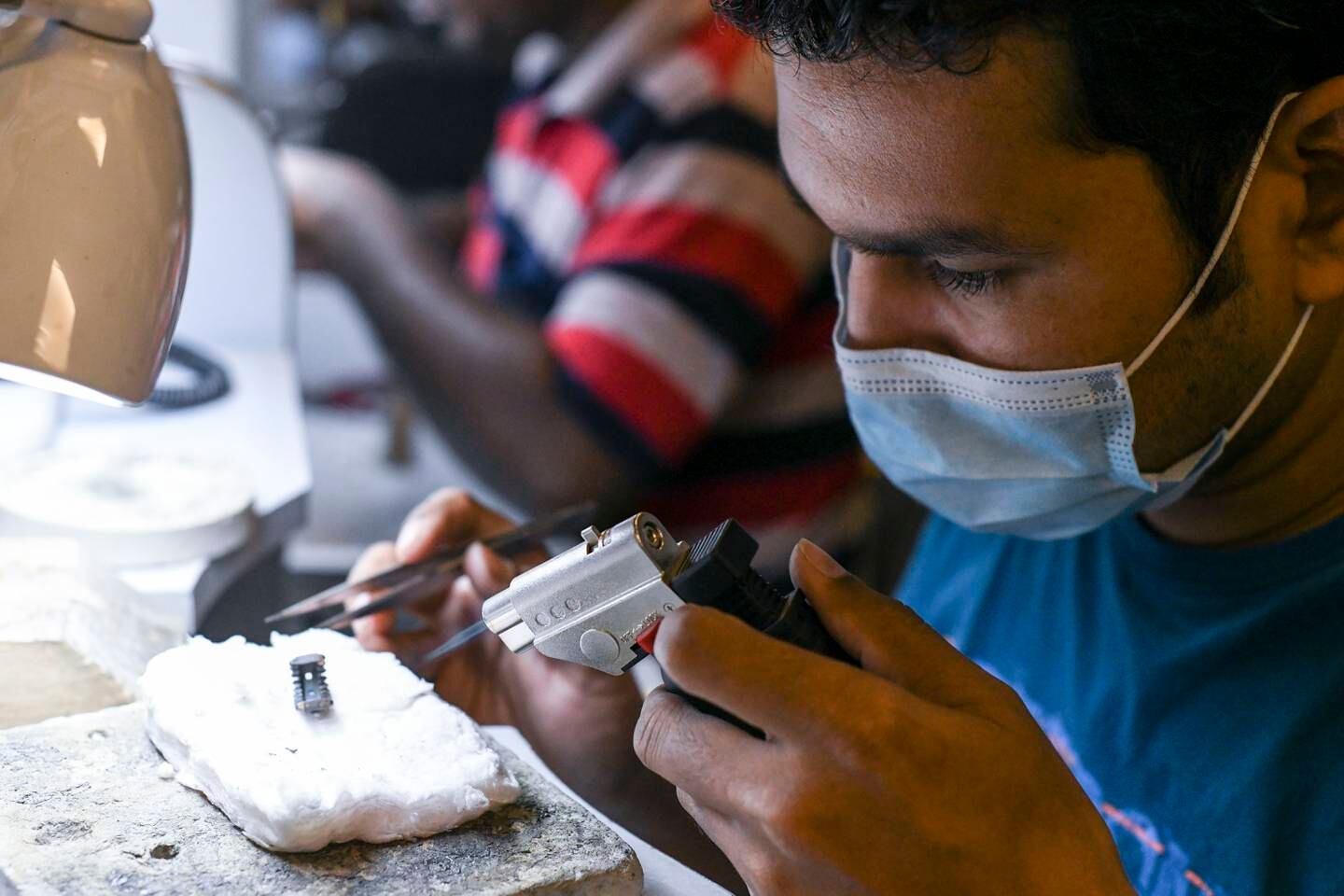 Samir Maity, a skilled craftsman from West Bengal, uses a welding torch for soldering the jewellery item at the Mussafah studio. Khushnum Bhandari / The National
