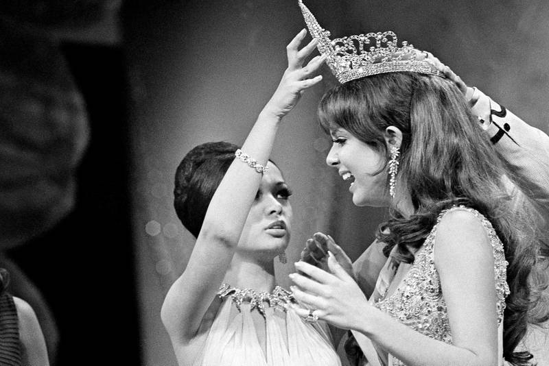 Marison Malaret, right, of Puerto Nuevo, Puerto Rico, recevies the Miss Universe crown from last year's title holder, Gloria Diaz of the Phippines during ceremonies  April 11, 1970 on Miami Beach.   Miss Malaret has brown hair, green eyes, stands five feet, eight inches tall and weighs 125 pounds. Her measurements are 35-23-35.    (AP Photo/Jim Bourdier)