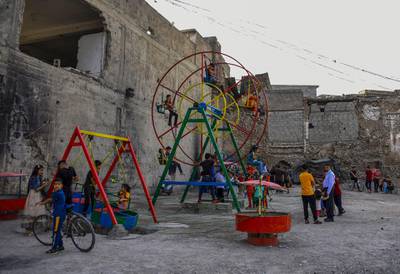 Iraqi children play at a playground during celebrations of the Eid Al Fitr in the old city of Iraq's northern Mosul. AFP