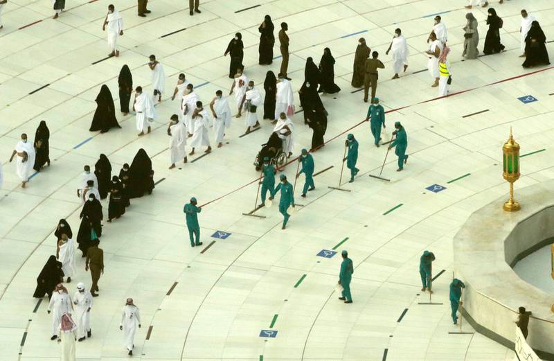 Workers disinfect the ground as Muslim pilgrims walk round the Kaaba, during the Umrah pilgrimage, in Makkah, Saudi Arabia. AP Photo