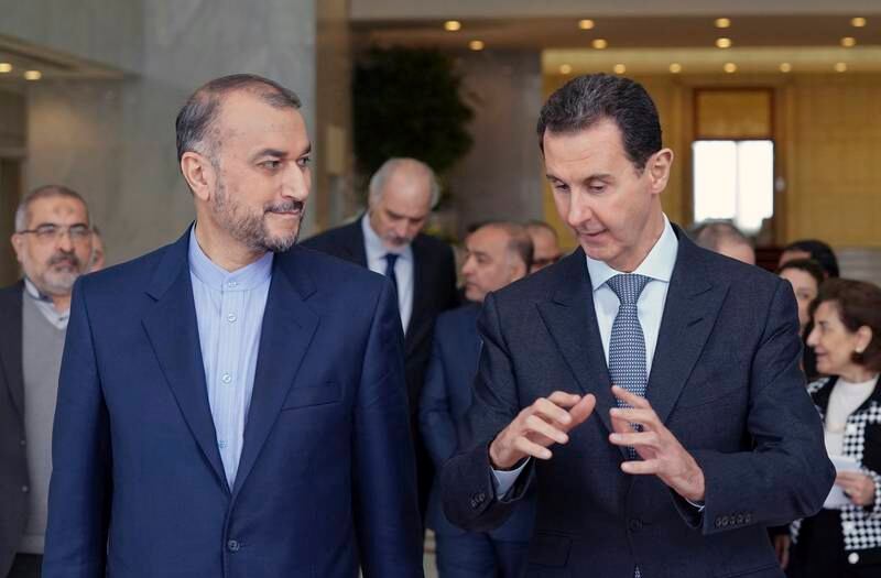 Iranian Foreign Minister Hossein Amirabdollahian and Syrian President Bashar Al Assad speak in Damascus on March 23, 2022. Sana via AP