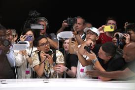 Members of the media inspect the new Apple Vision Pro headset on Monday. AFP
