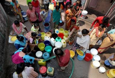 People in a slum in Kolkata, India, collect drinking water from a municipal container tank. EPA