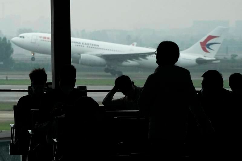 Passengers wait for their flight as a China Eastern flight takes off from the runway of Baiyun Airport on Friday, March 25, 2022, in Guangzhou province, southern China. AP