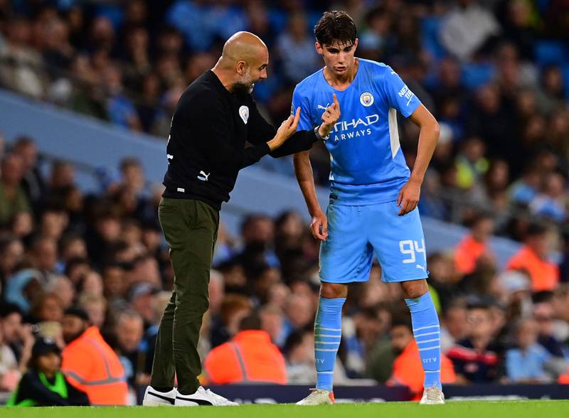 Manchester City manager Pep Guardiola speaks with defender Finley Burns during a League Cup third round football match against Wycombe Wanderers at the Etihad Stadium in September, 2021. AFP
