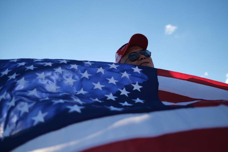 A supporter of U.S. President Donald Trump holds a U.S. flag before an election campaign rally at Orlando Sanford International Airport in Sanford, Florida, U.S. October 12, 2020.  REUTERS/Ricardo Arduengo