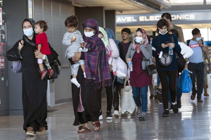 Families flown out of Kabul walk through Washington Dulles International Airport after arriving in the US. AP