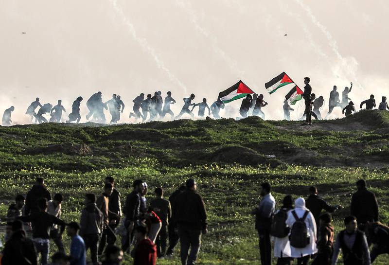 epa07353875 Palestinian protesters run for cover from Israeli tear-gas during clashes after Friday protests near the border between Israel and Gaza Strip, east Gaza, 08 February 2019. According to local media reports, Two Palestinians 14 and 17 years-old boys were shot dead allegedly by Israeli snipers during clashes along the border between Gaza Strip and Israel. Palestinian protesters call for the right of Palestinian refugees across the Middle East to return to homes they fled in the war surrounding the 1948 creation of Israel.  EPA/MOHAMMED SABER