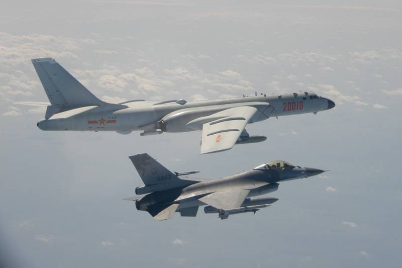 A Taiwanese F-16 fighter jet flying next to a Chinese H-6 bomber, top, off the coast of Taiwan. AFP
