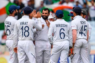 India's Mohammed Shami, centre, celebrates after taking the wicket of Zubayr Hamza. AFP