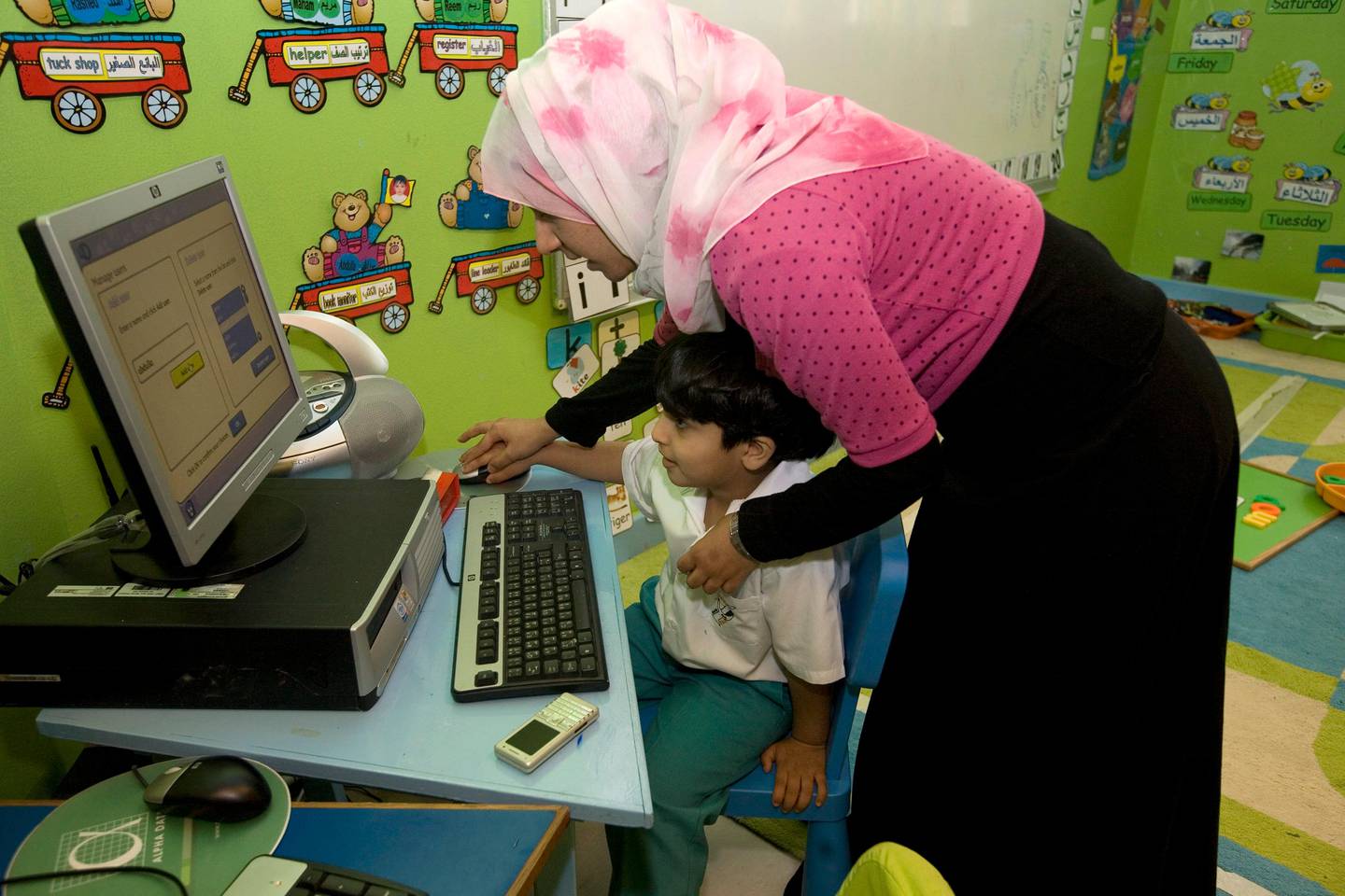 Abu Dhabi, UAE - February 19, 2009 - Sammar Dawood teaches a kindergarten student a computer game at Al Yasat school.  (Nicole Hill / The National) *** Local Caption ***  NH AlYasat09.jpgNH AlYasat09.jpg