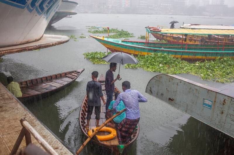 People cross the Buriganga River as they shelter from the rain and rough conditions in Dhaka, Bangladesh. EPA