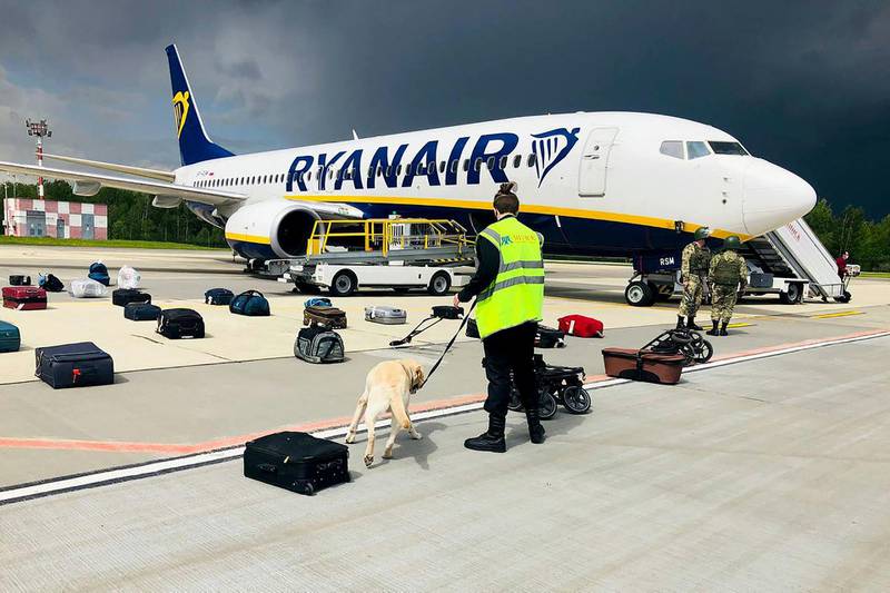 A Belarusian dog handler checks luggage off a Ryanair plane parked at Minsk International Airport. AFP