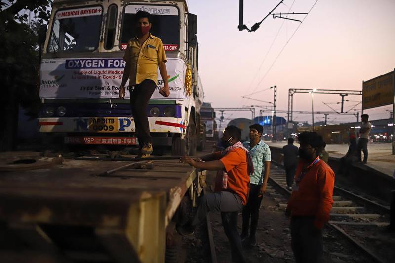 Workers unload a medical oxygen tanker from the 'Oxygen Express' train at Delhi Cantonment railway station. Bloomberg