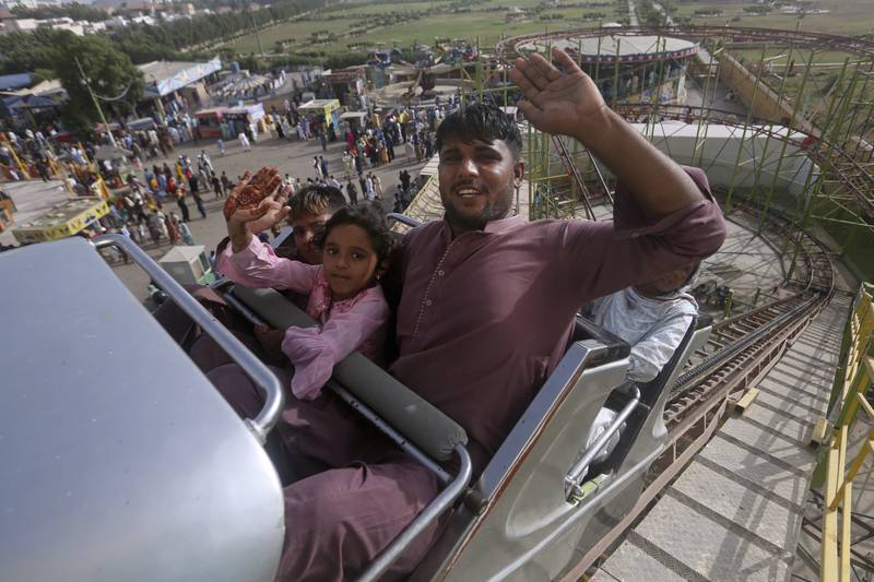 A family at a fun fair during the Eid Al Fitr holiday, marking the end of Ramadan, in Karachi, Pakistan. AP